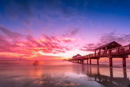 coral hued sunrise in clearwater beach by the pier